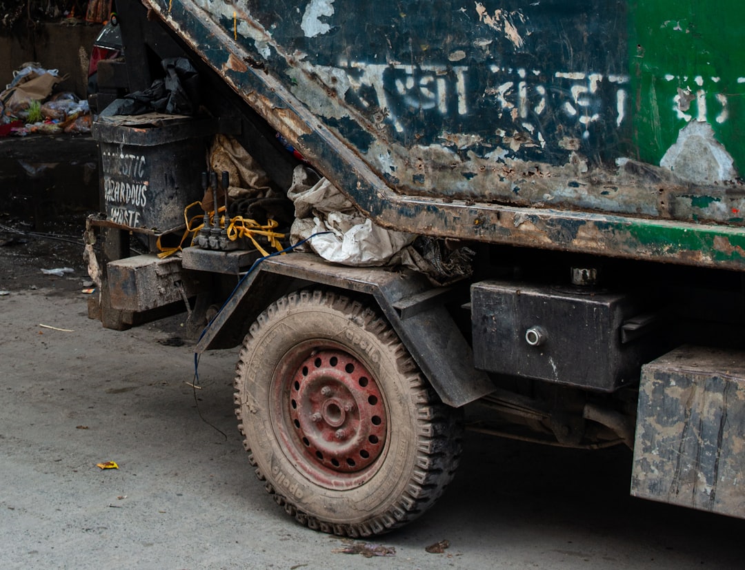 Close-up of a dirty garbage truck with a flat tire | The National Recycling Corporation
