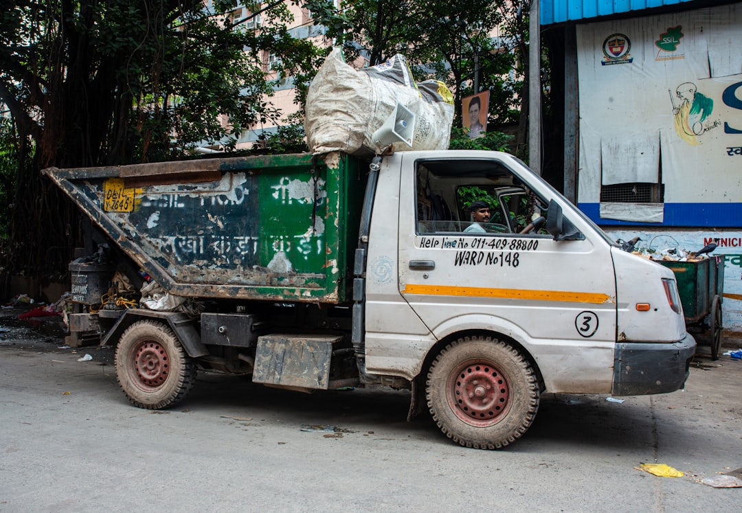 A white garbage truck filled with trash. | The National Recycling Corporation