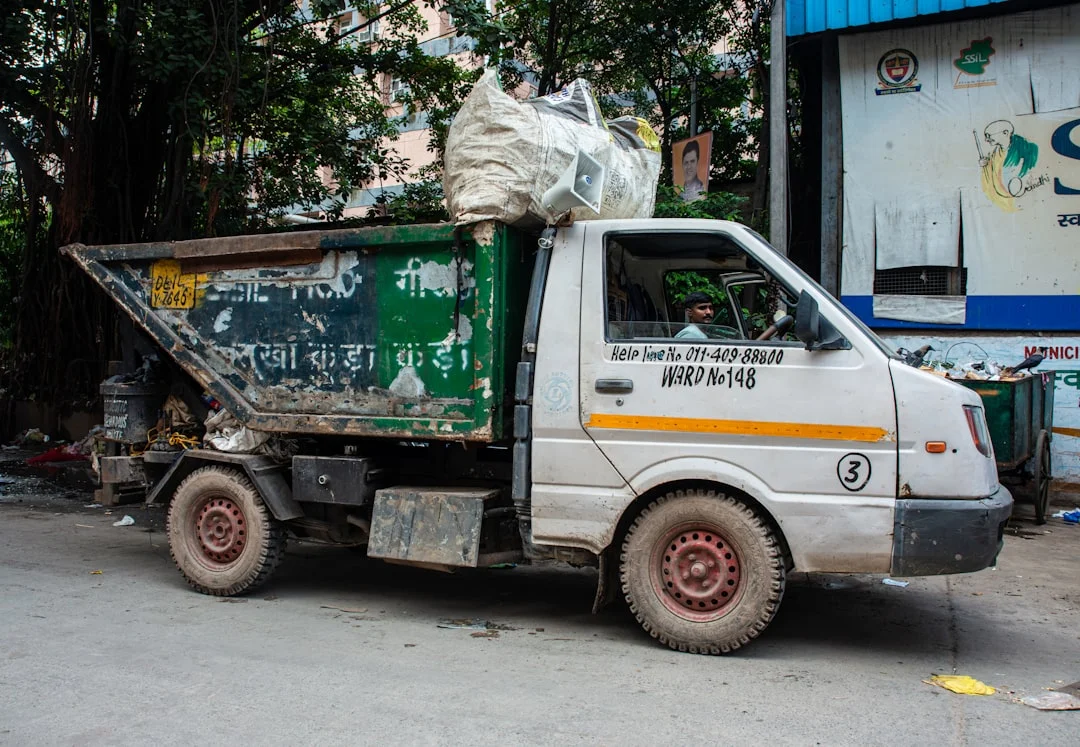 A white garbage truck filled with trash. | The National Recycling Corporation