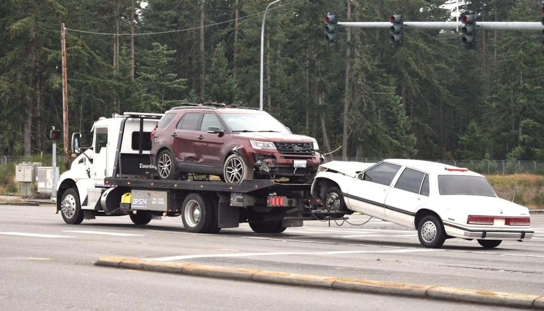 A tow truck towing a car on the road | The National Recycling Corporation